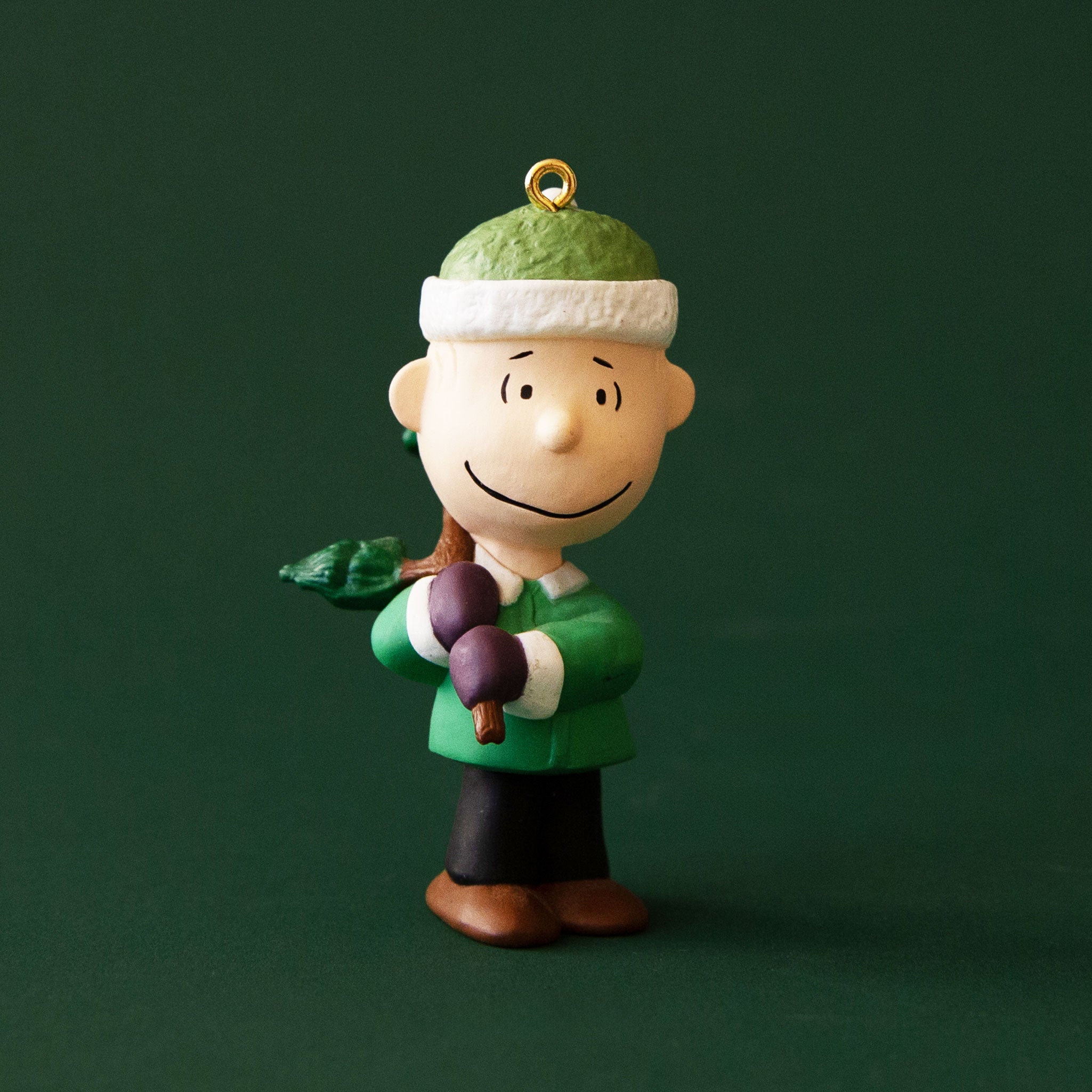 An ornament of Linus with a tree over his shoulder. 