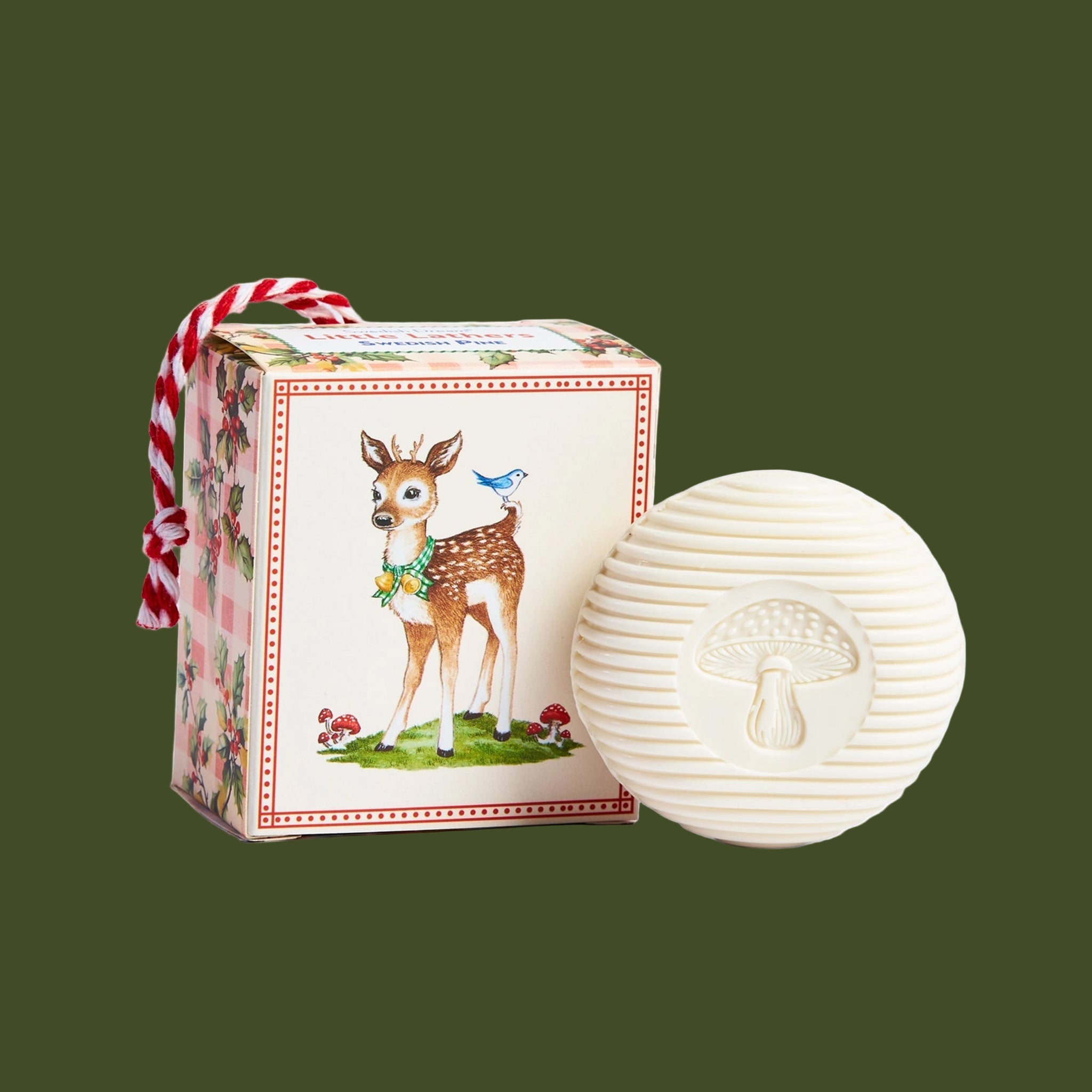 A box ornament with an illustration of a reindeer and inside is a white bar of soap. 