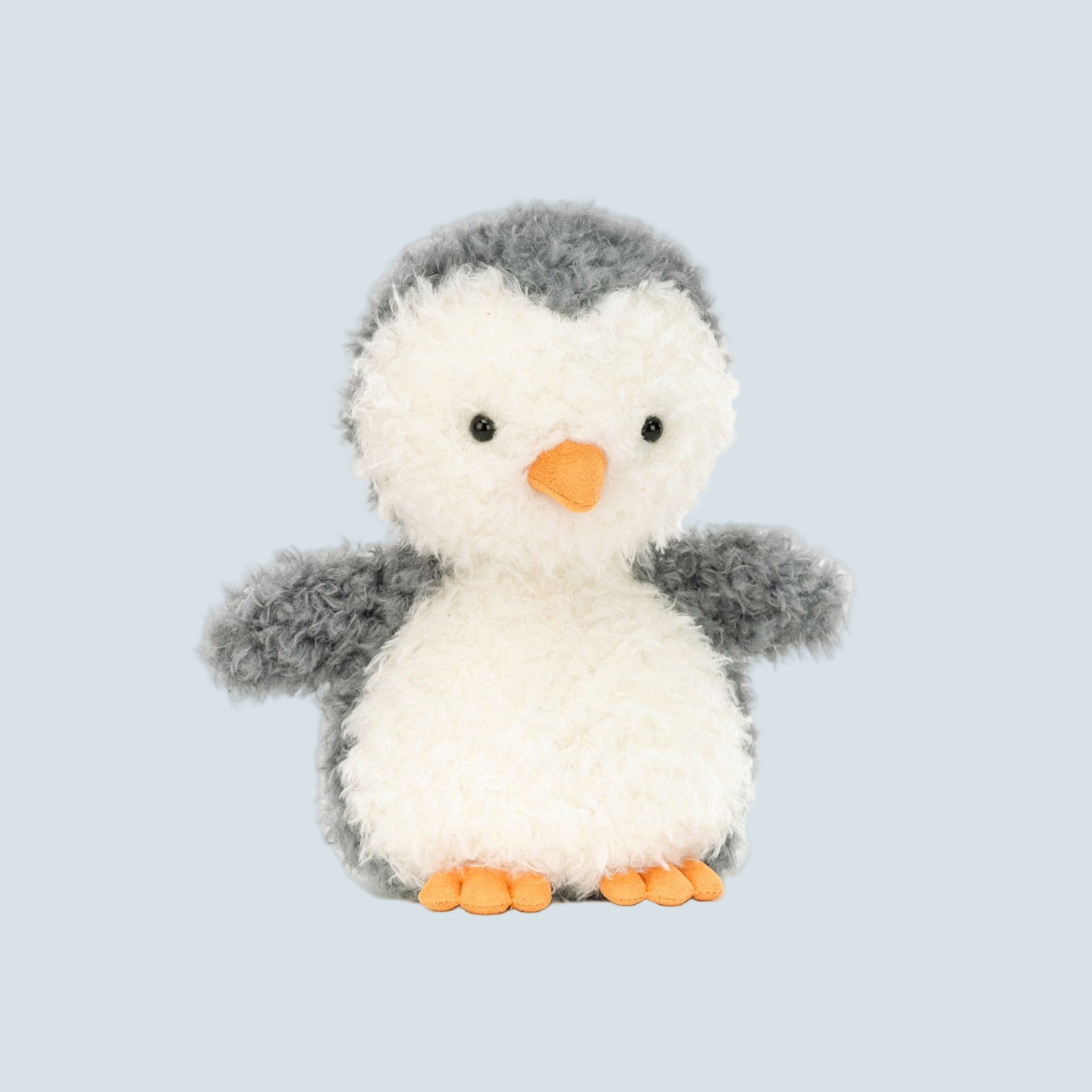 A grey and white penguin shaped stuffed animal. 