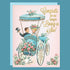 A pink card with a vintage carriage illustration with a newlywed couple paired with a blue envelope and gold foiled text that reads, 'Congrats on no longer living in sin!'. 