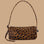 A brown and black leopard print loaf shaped shoulder bag.