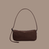 A brown nylon shoulder bag on a brown background.