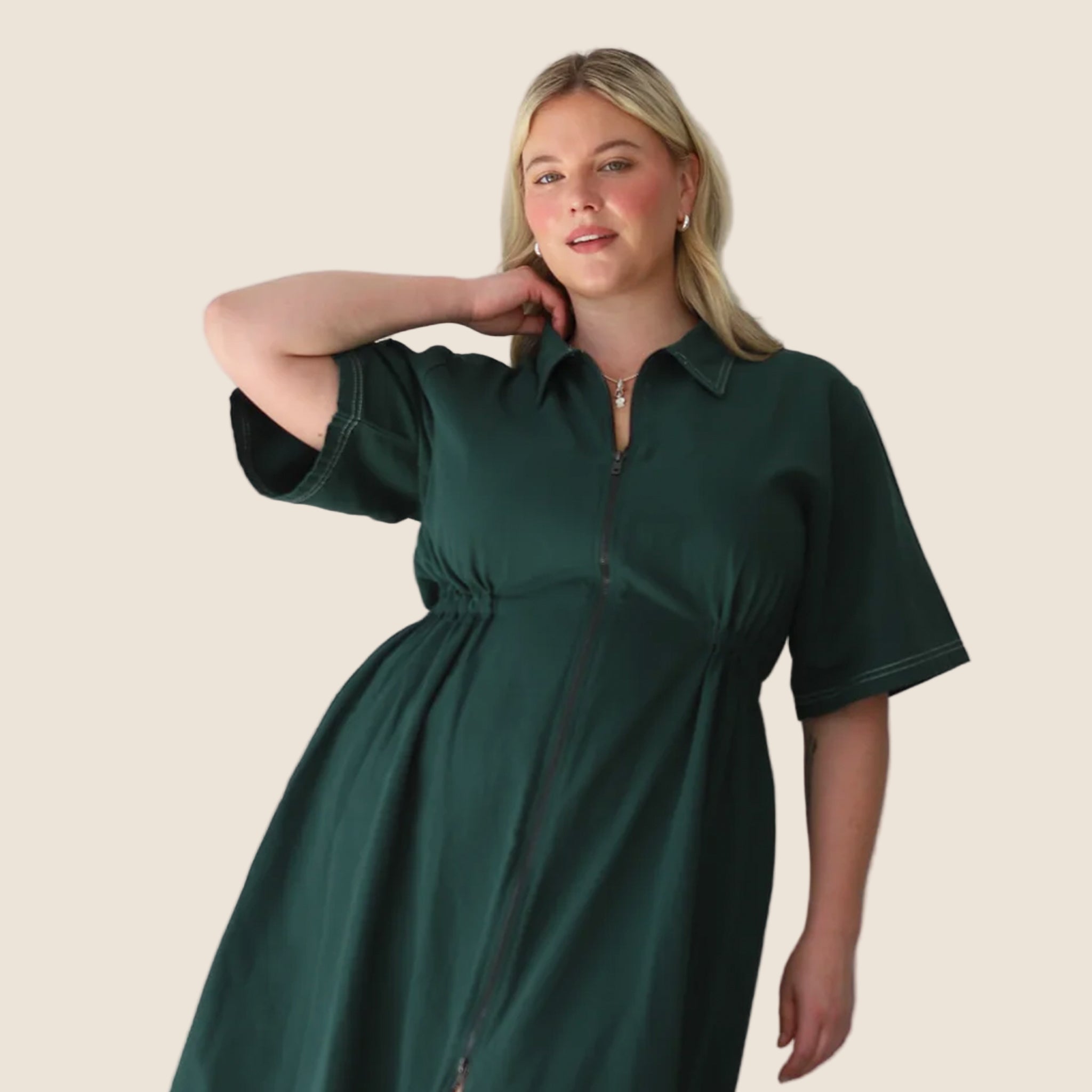 A dark green long utility dress with a zipper and short sleeves.