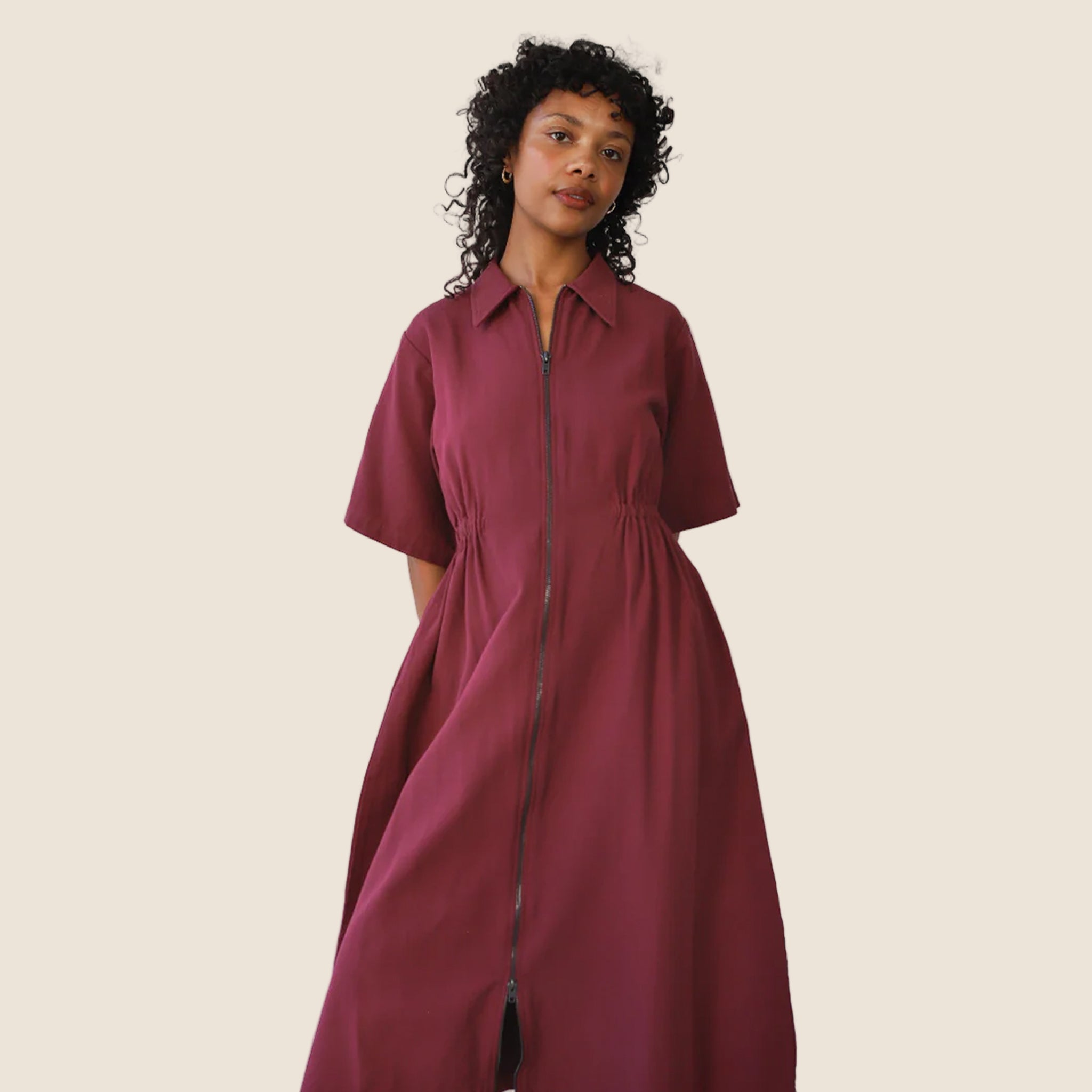 A long dark red zipper dress with a collar and short sleeves. 