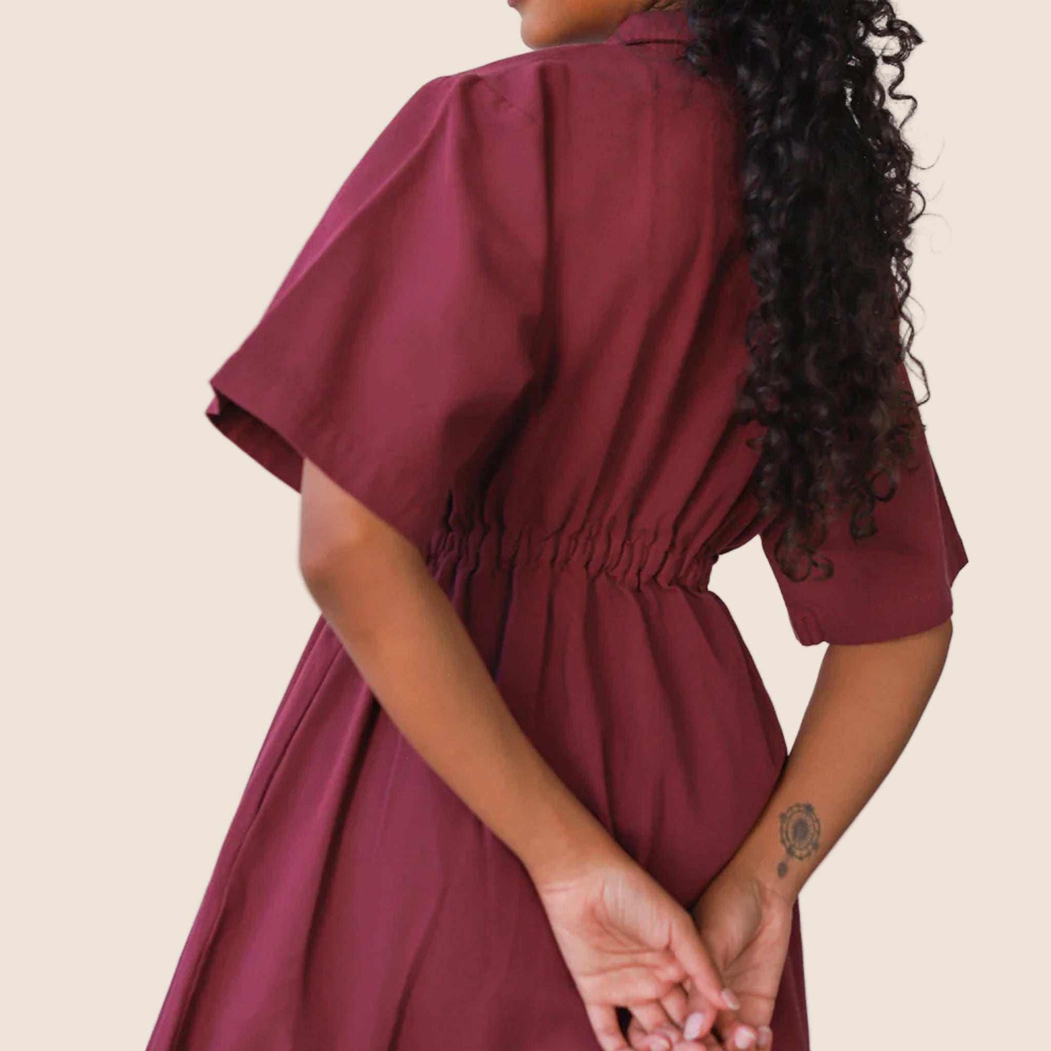 A long dark red zipper dress with a collar and short sleeves. 