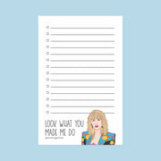 A white notepad with black lines that has an illustration of Taylor Swift at the bottom with the text, "look what you made me do."