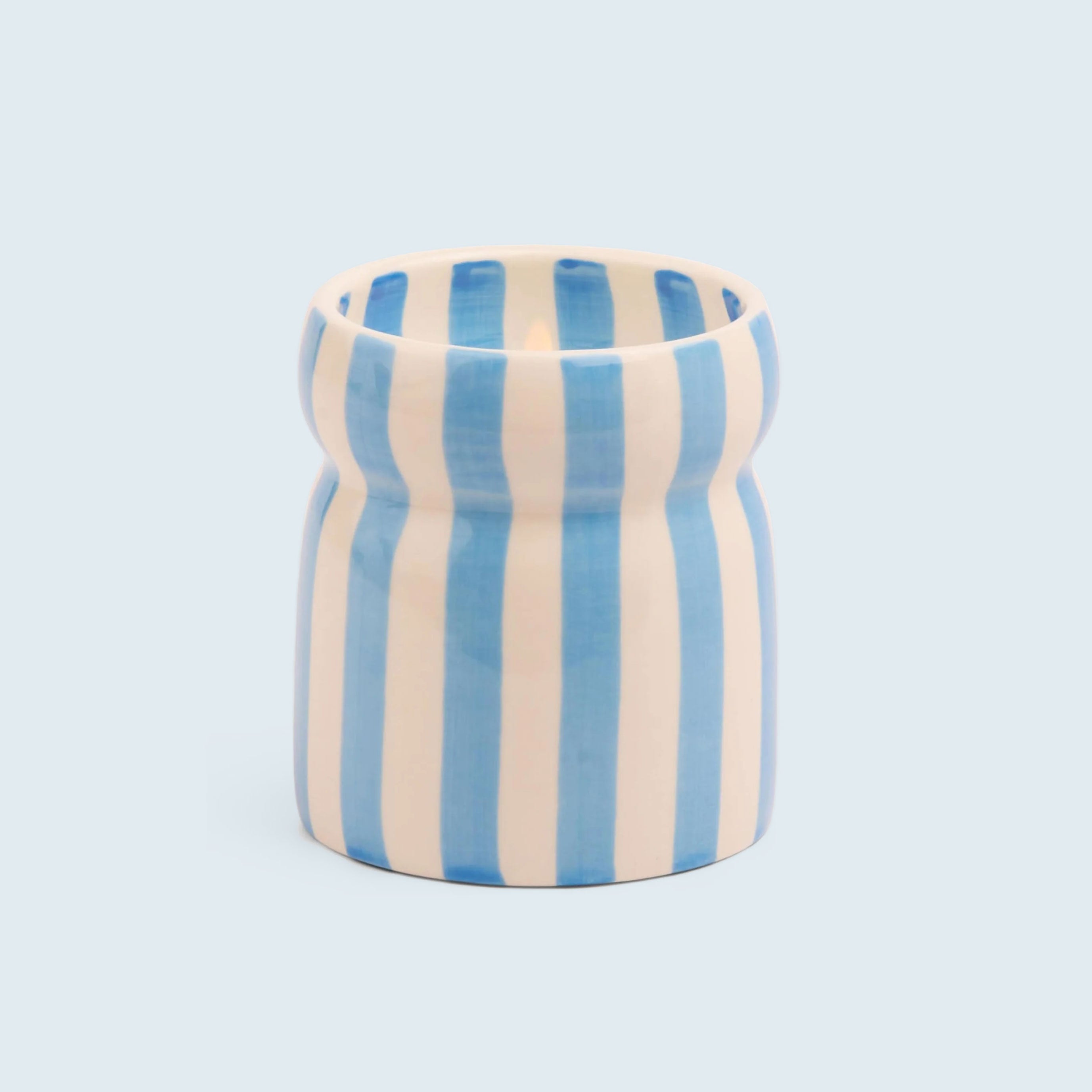 A blue and cream striped ceramic candle