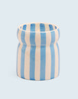 A blue and cream striped ceramic candle