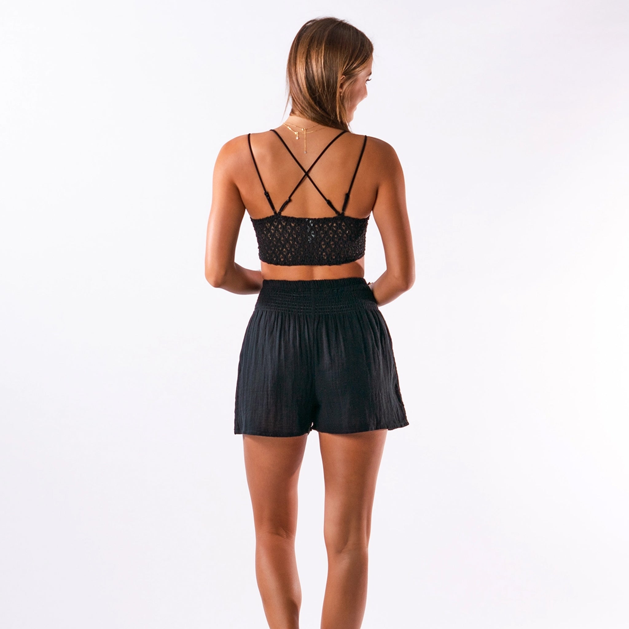 A model wearing black flowy cotton shorts with an elastic waistband.