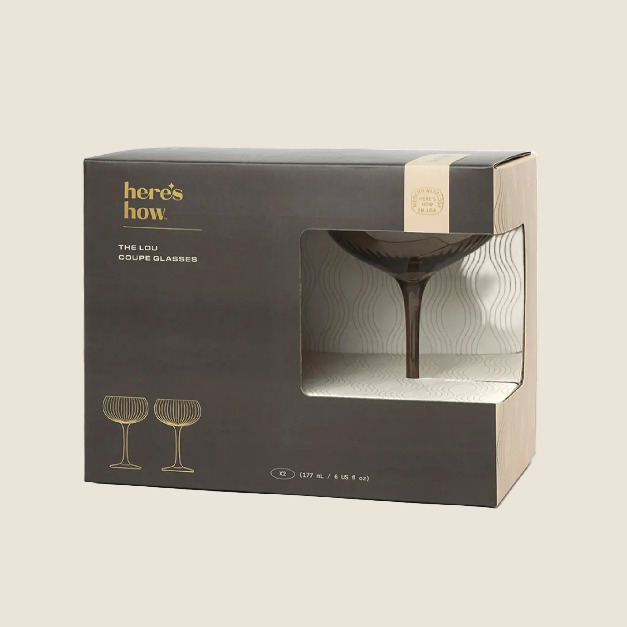 A set of glass coupe glasses in a smokey grey color. 