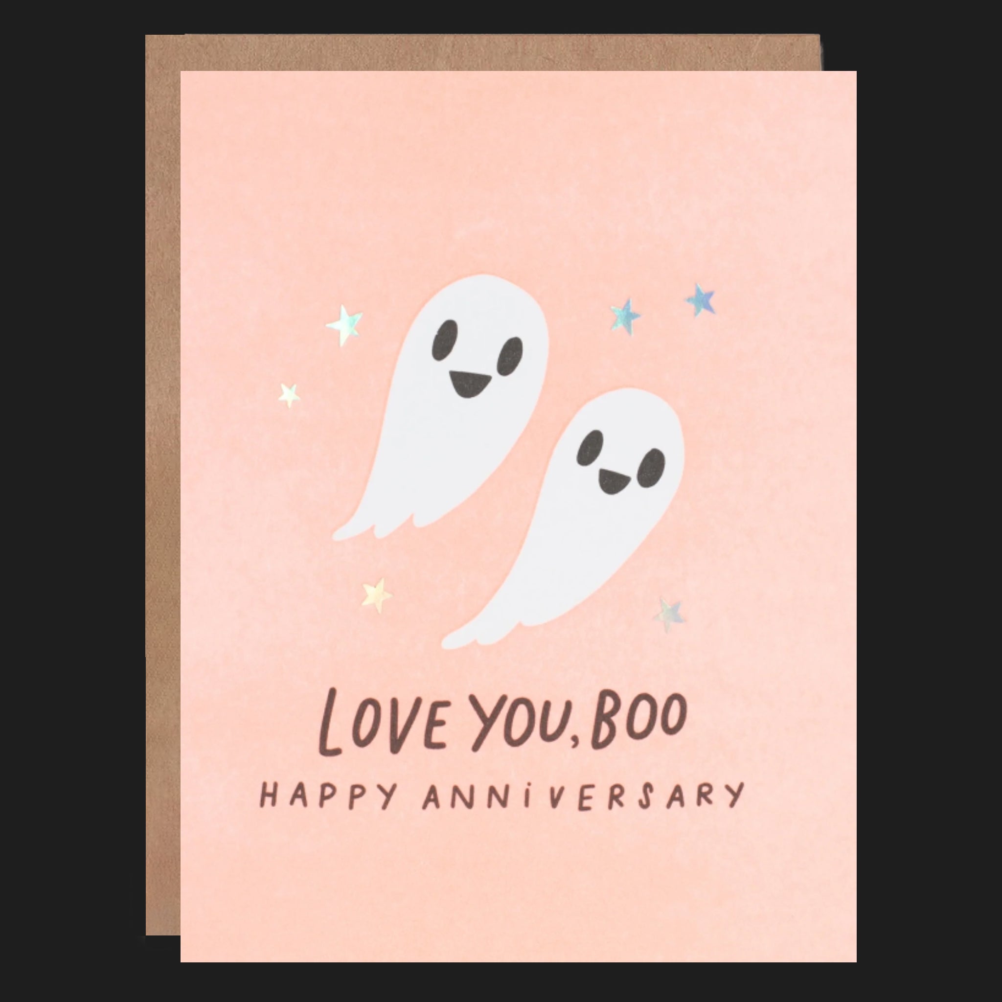 A peachy colored card with an illustration of ghosts and text below that reads, &#39;Love You, Boo Happy Anniversary&#39;. 