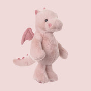 A light pink dragon shaped stuffed animal. 