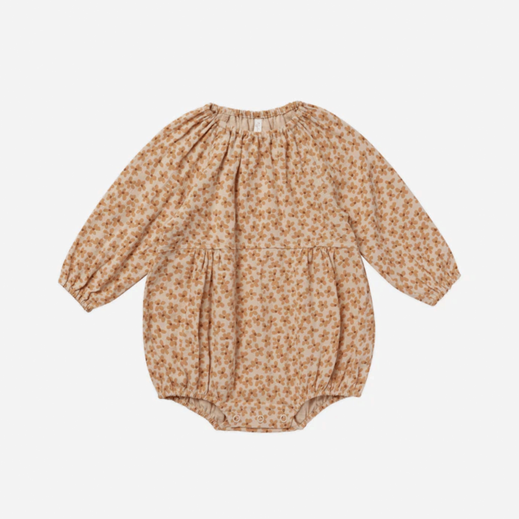 On a white background is a tan long sleeve baby romper with a similar colored floral print on it.