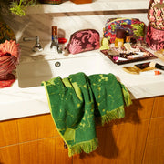 a green hand towel with a floral/leaf print. 