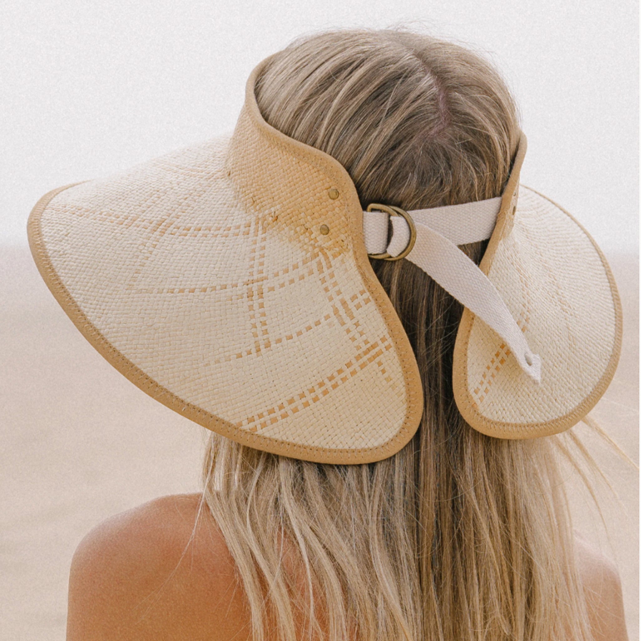 A woven tan and light tan visor sun hat.