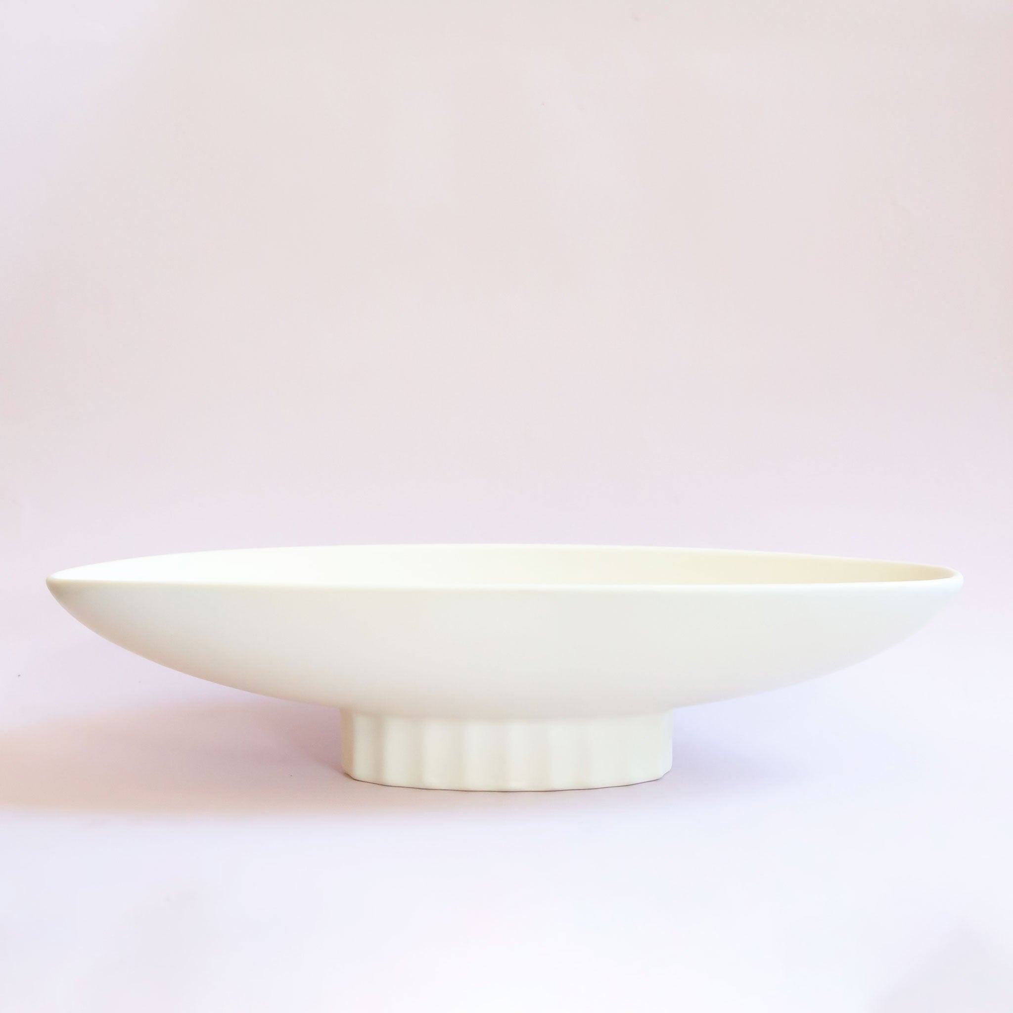 An elongated ceramic pedestal bowl. 