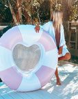 A pink and white striped pool float but the center is in the shape of a heart with a mesh backing. 