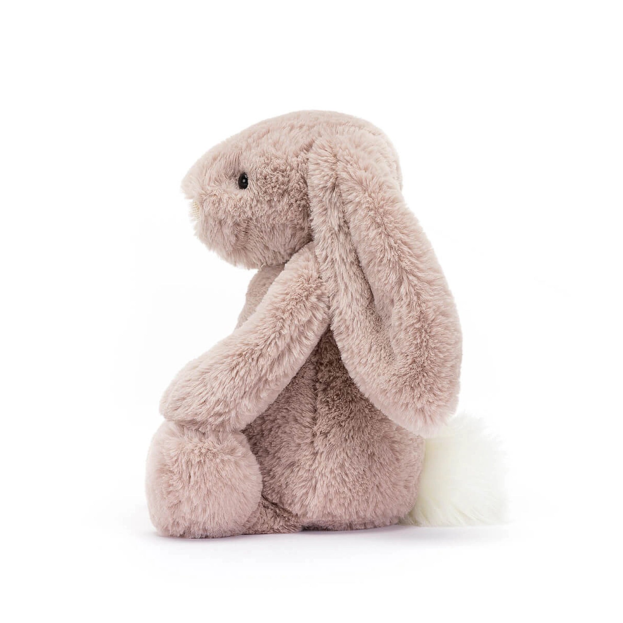 On a white background is a light pink stuffed animal bunny with long floppy ears and super soft faux fur.