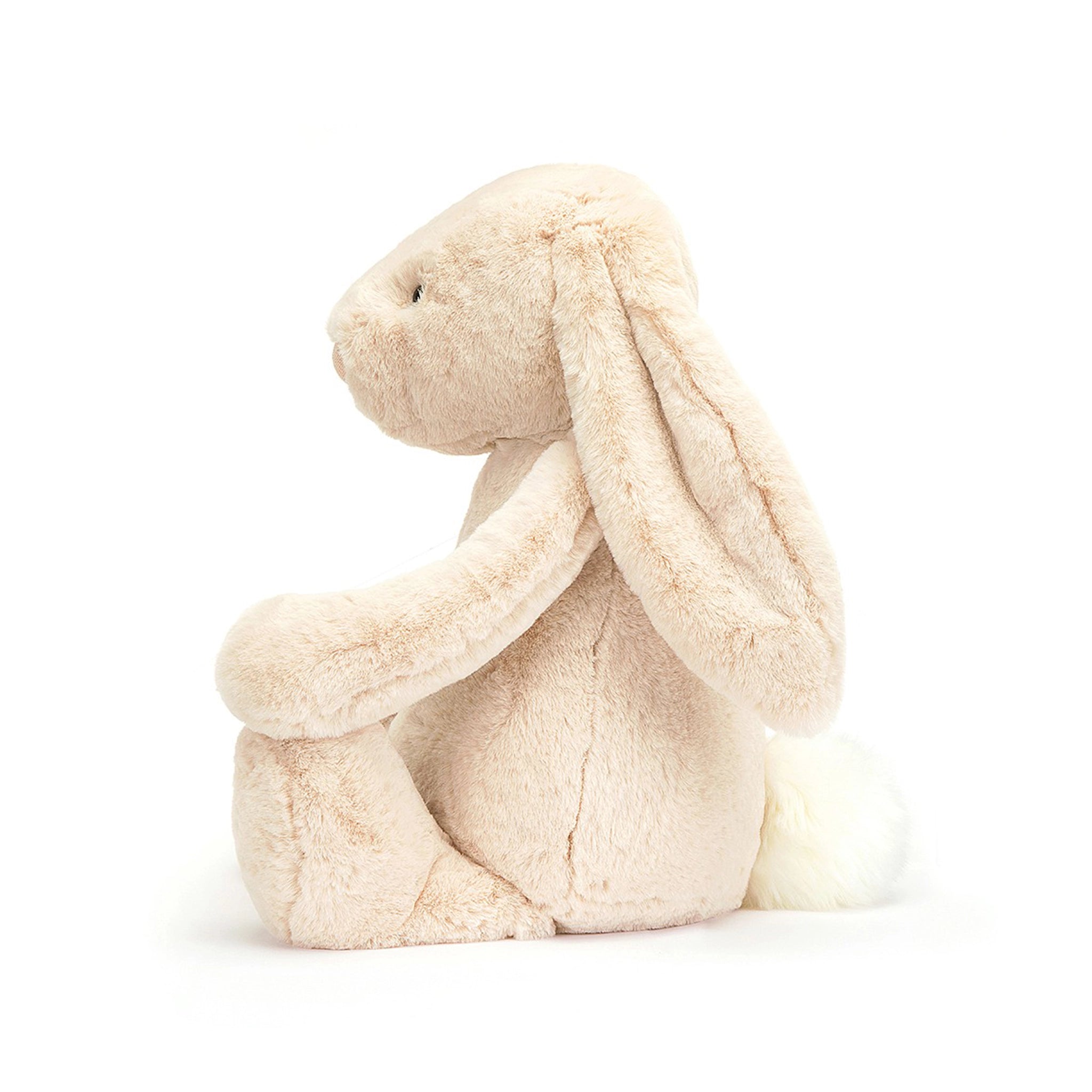 On a white background is a cream colored stuffed animal bunny with long floppy ears and super soft faux fur plus a fluffy tail. 