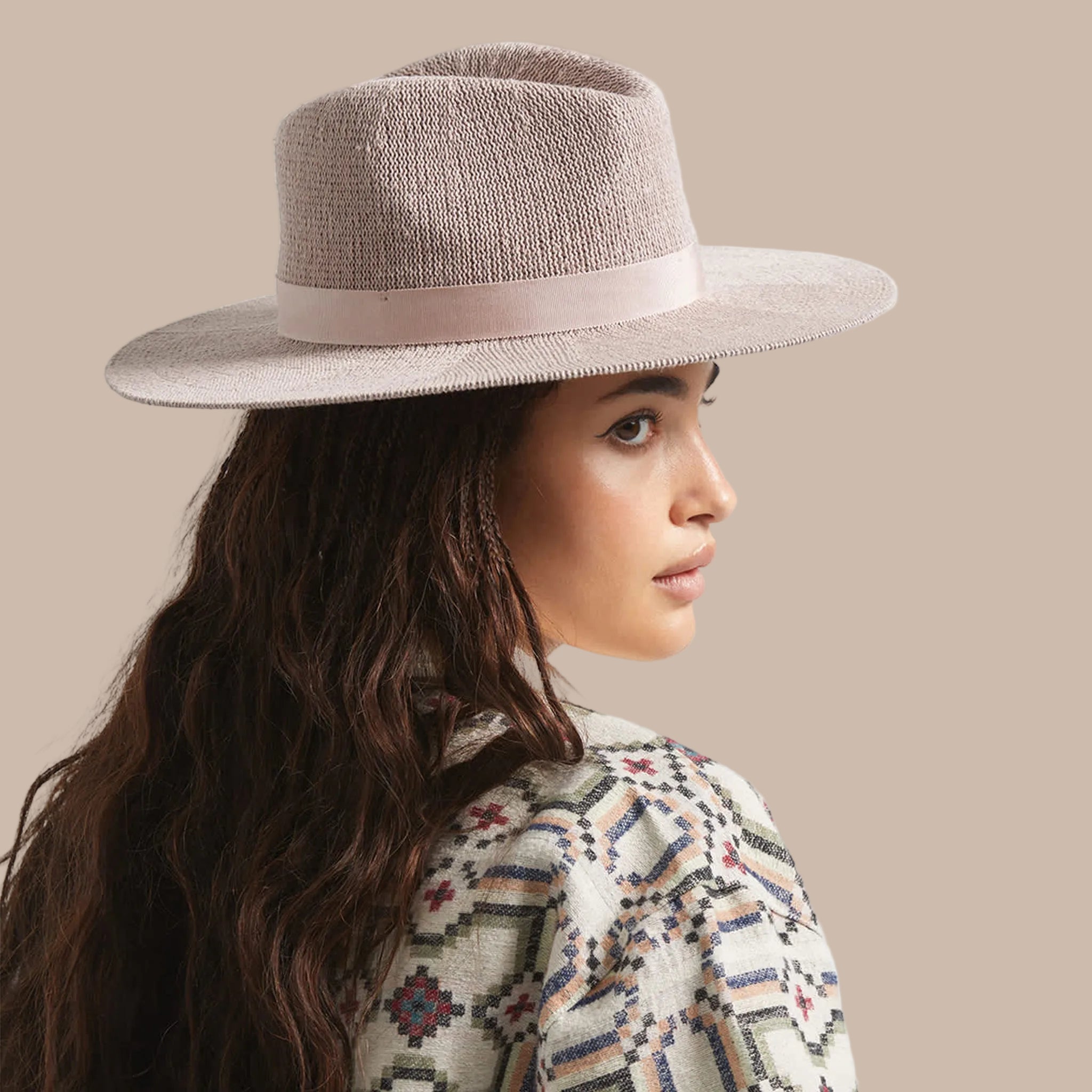 A neutral mauvy tan packable straw sun hat. 