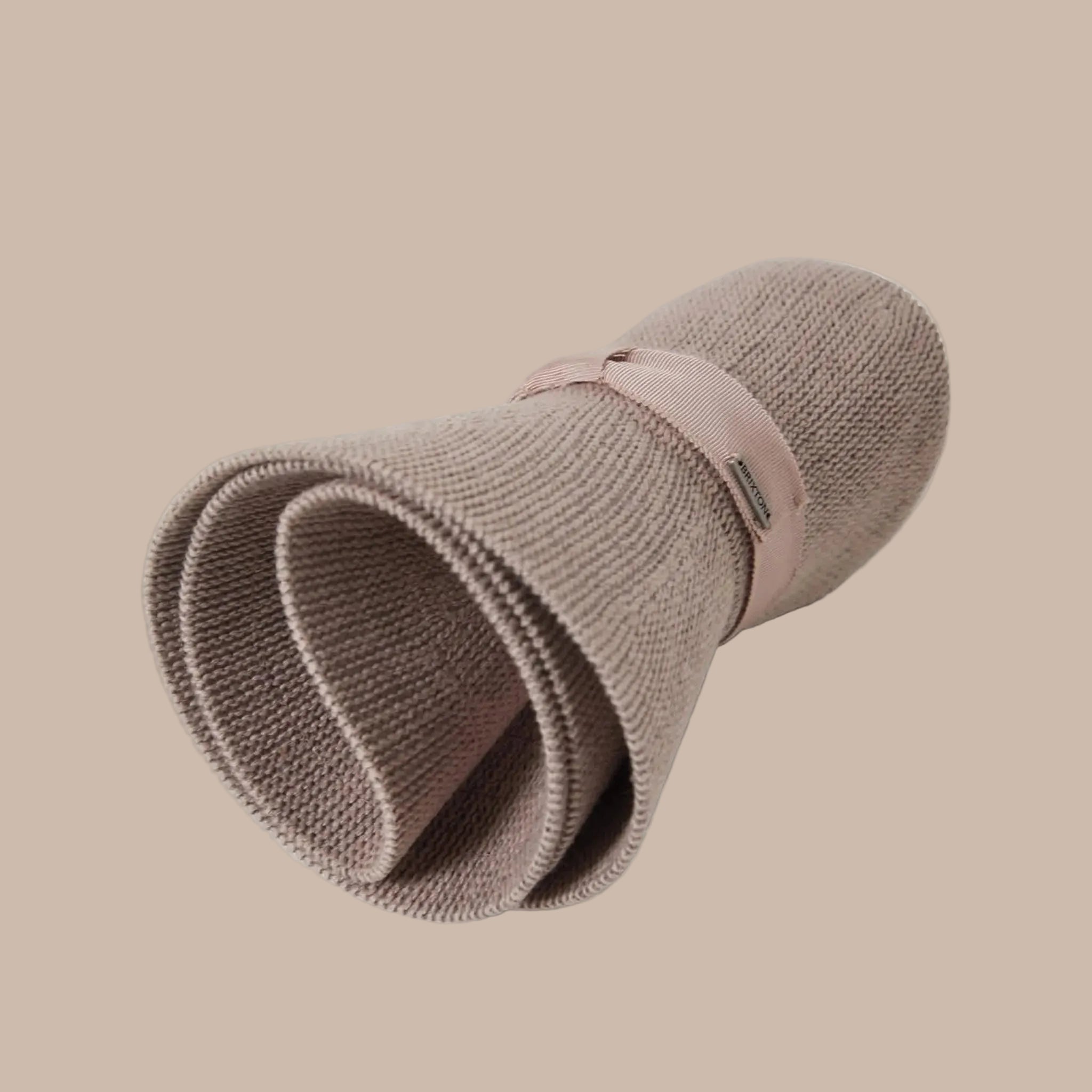 A neutral mauvy tan packable straw sun hat. 