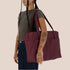 A large puffy nylon carry on tote bag in a mahogany color.