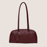 A reddish recycled leather bowling bag handbag with shoulder straps.