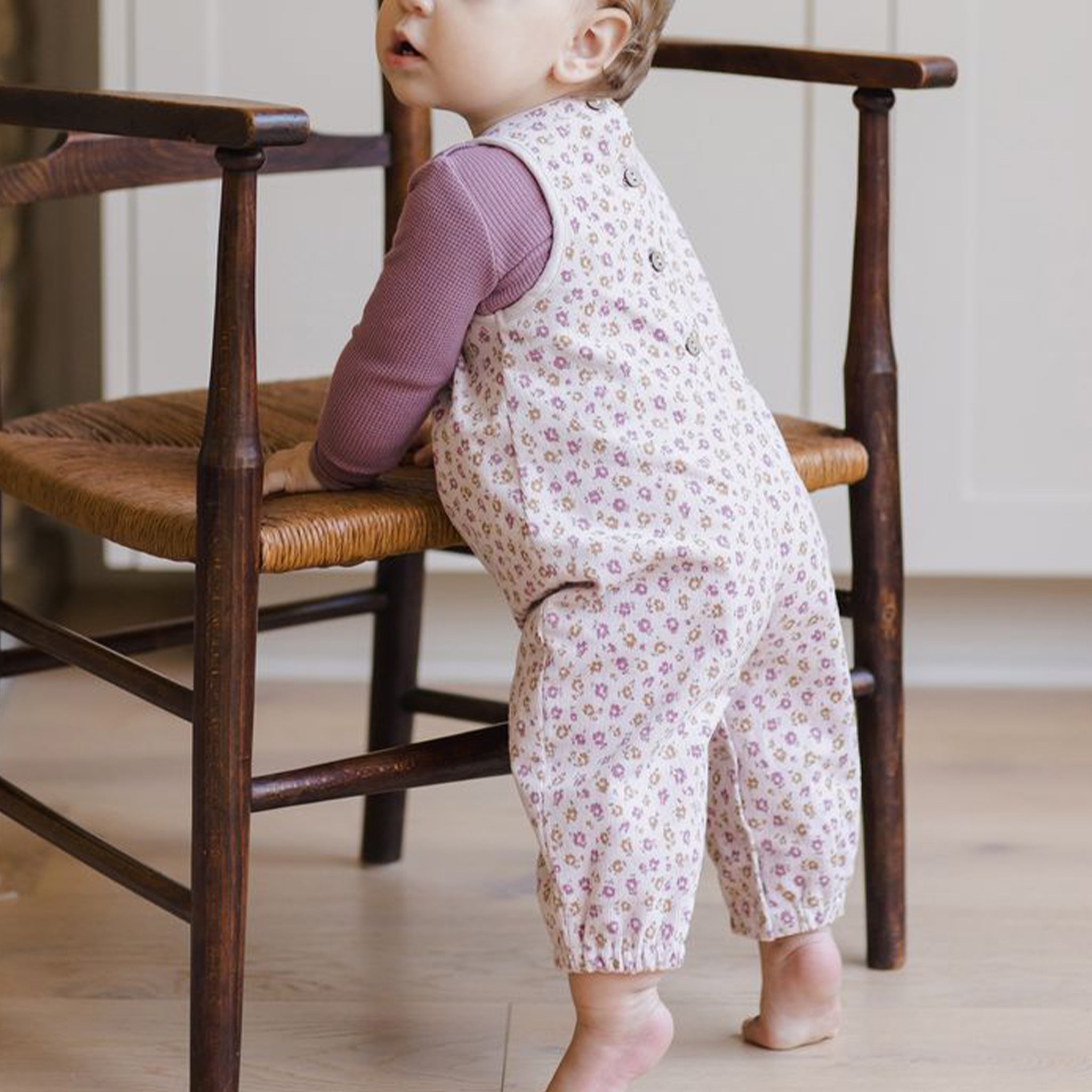 A pair of light pink floral overalls for kids. 