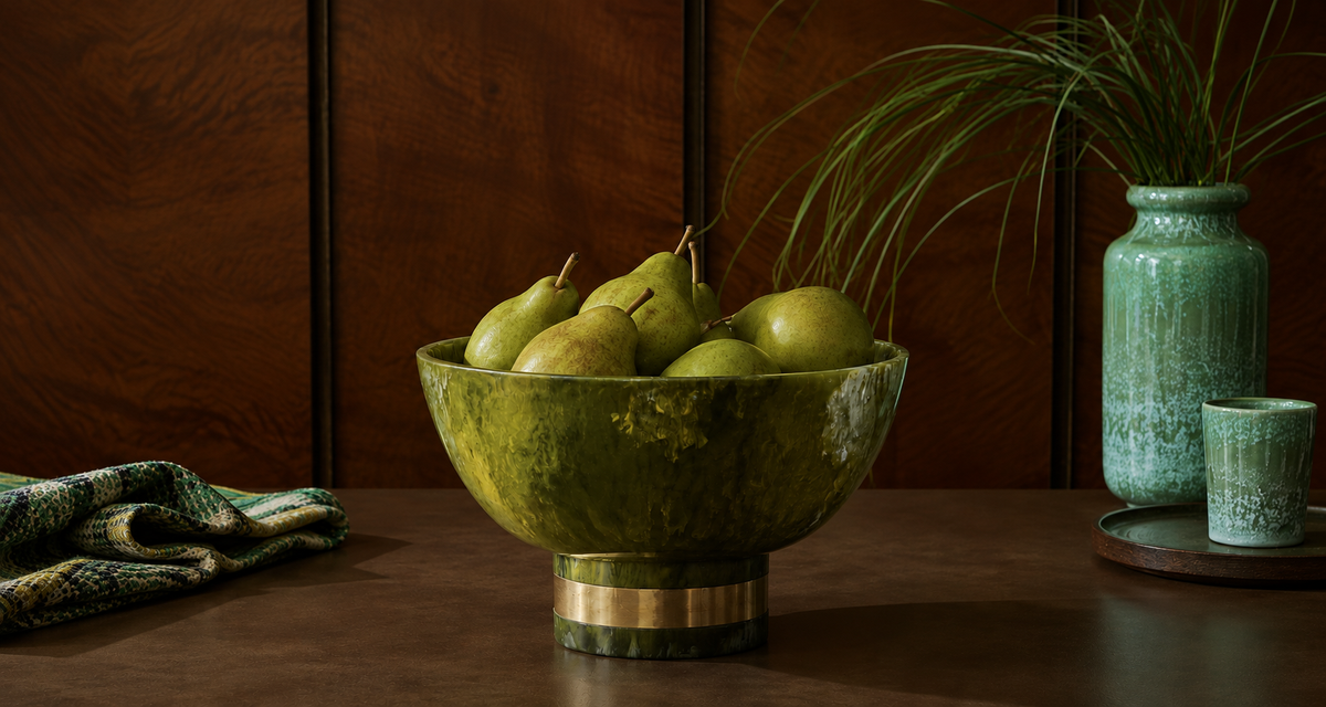 A wood kitchen wall and brown counter with pears featured in a green bowl with turquoise elements behind.
