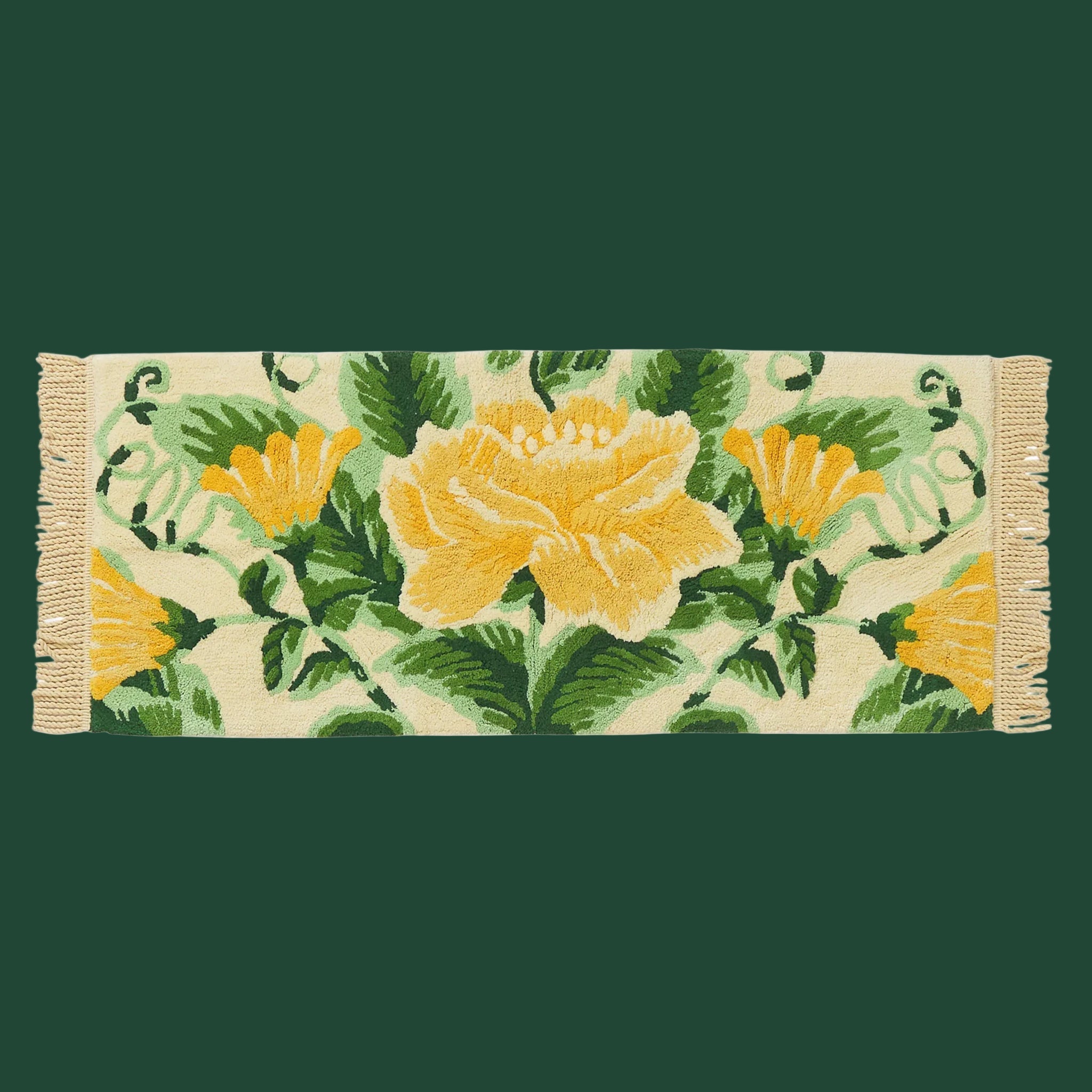 A green and yellow floral bath runner with fringe on each end. 