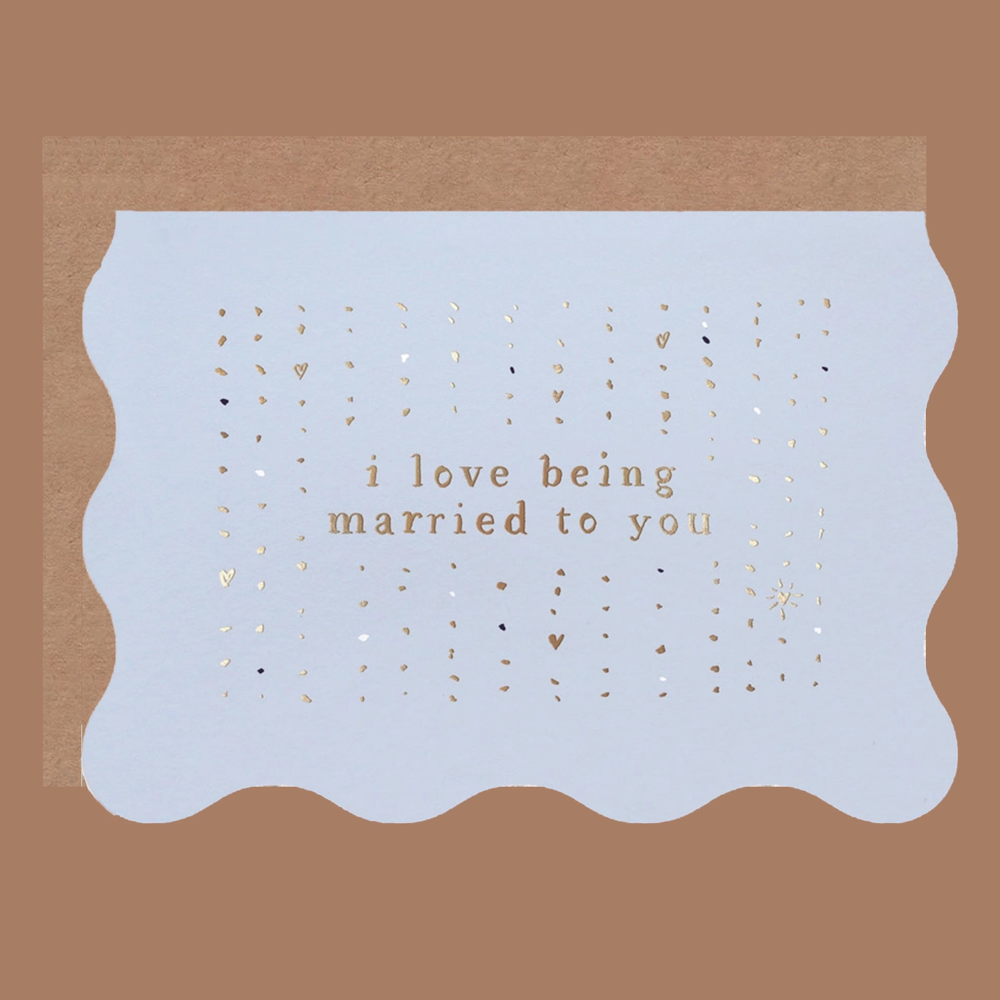 blue wavy edged card with gold foiled text that reads, &quot;i love being married to you&quot;.
