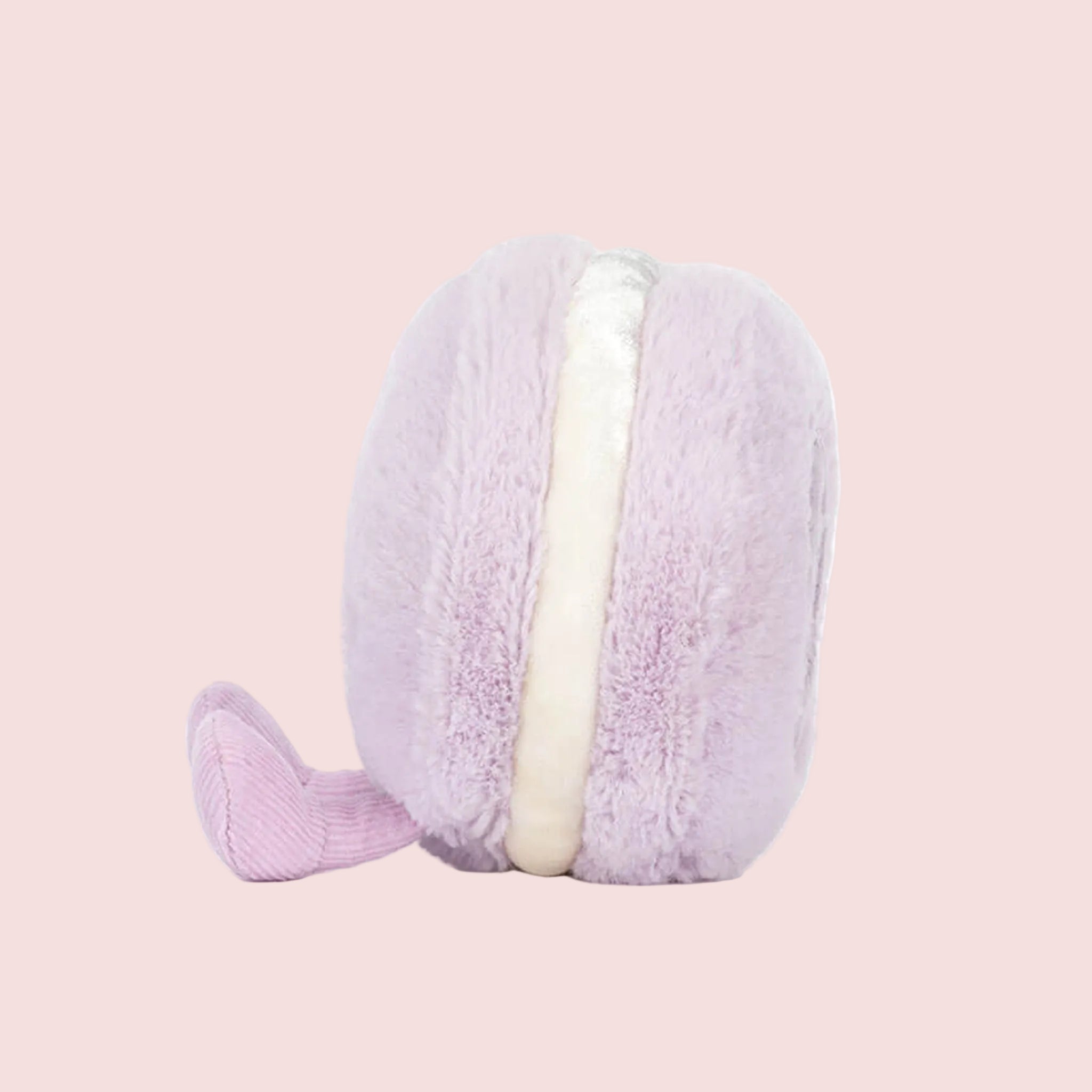 A macaron shaped stuffed toy with a smiling face and lavender corduroy legs and feet. 