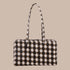 An ivory and brown blurred gingham print rectangle shaped nylon shoulder bag.