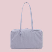 A light blueish-purple nylon rectangle shaped shoulder bag. 