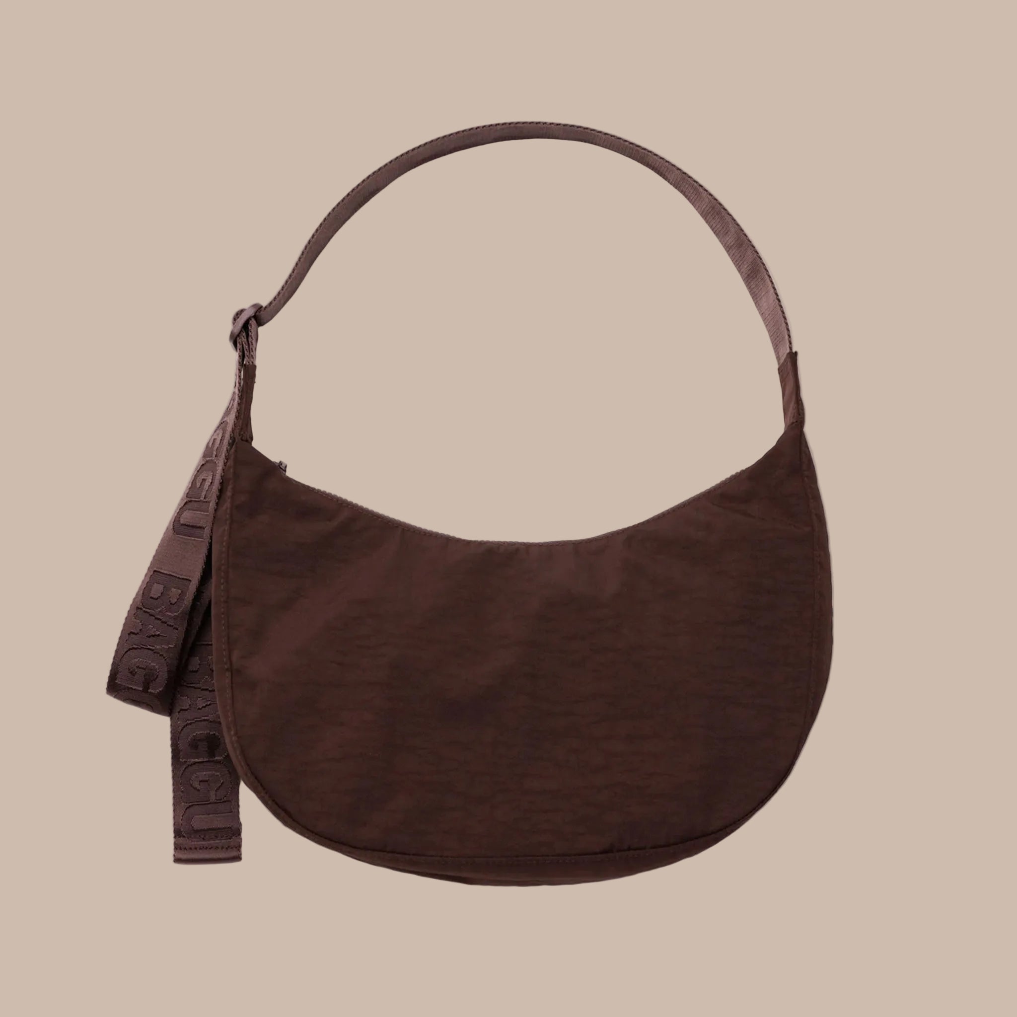 A dark brown crescent shaped bag with a shoulder strap and an adjustable crossbody. 