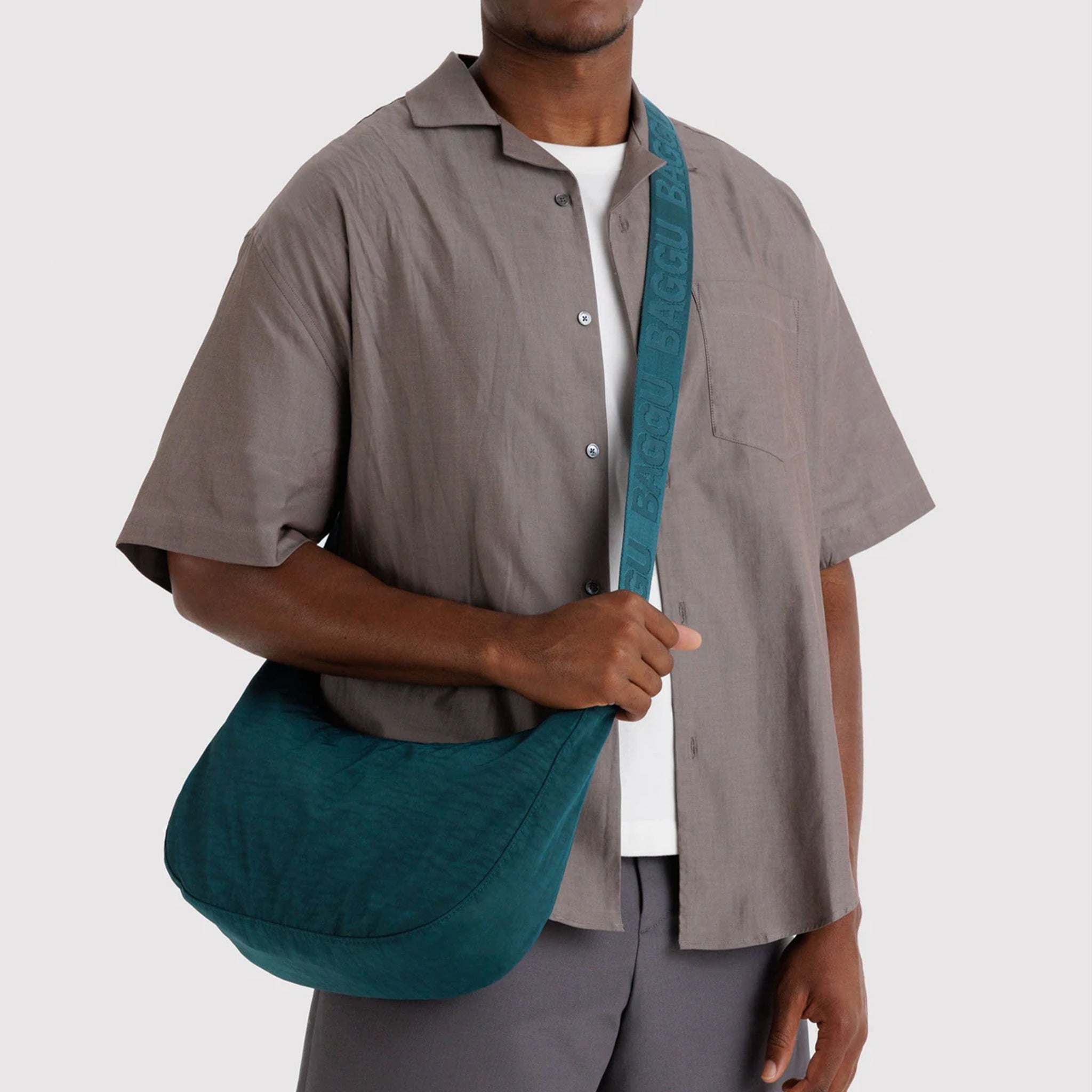 A dark teal colored crescent shaped purse. 