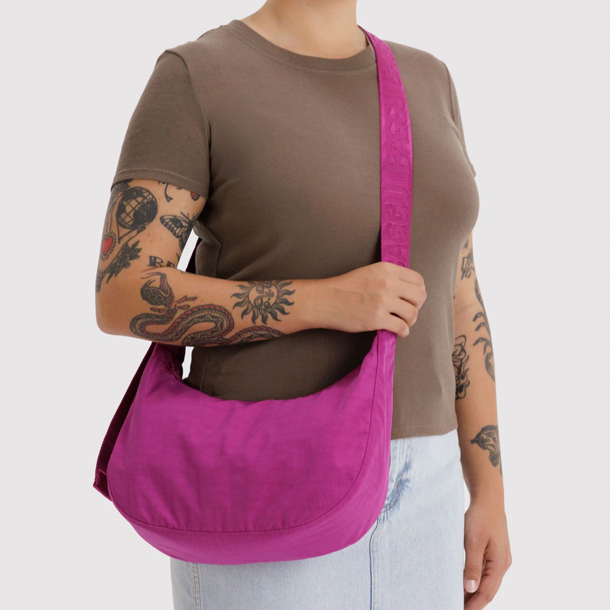 A hot pink crescent shaped shoulder bag. 