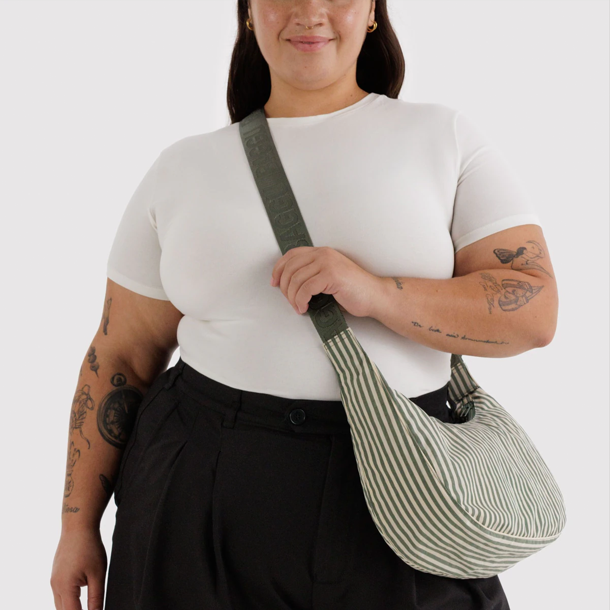 sage colored striped bag with sage colored straps on model.