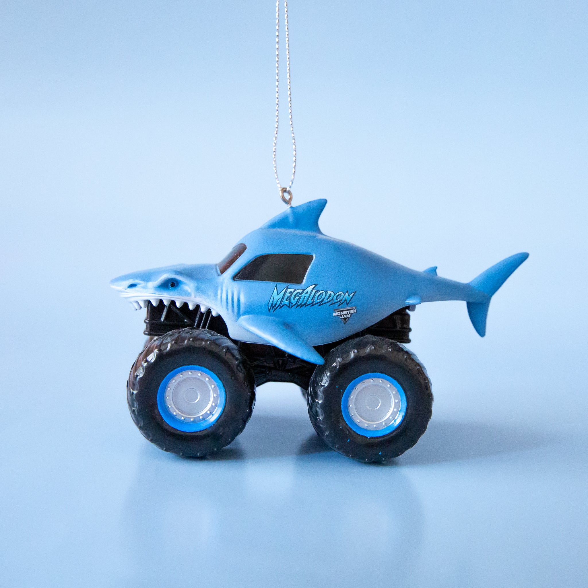 A blue Megalodon monster truck shaped ornament.