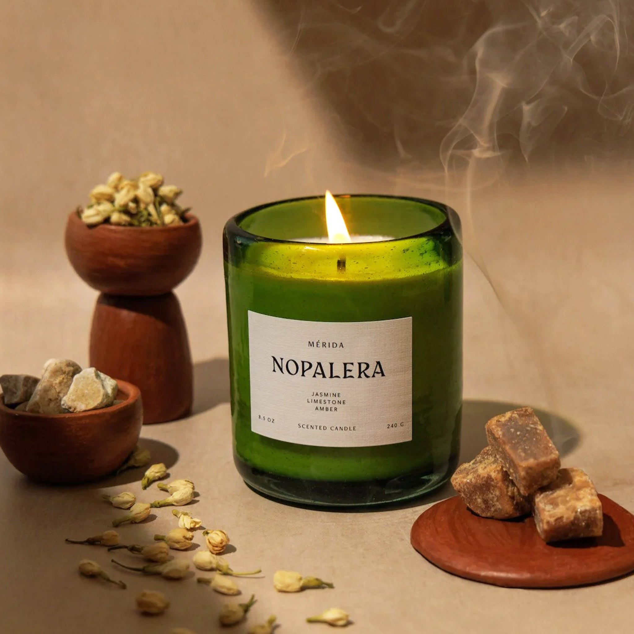 "Merida Nopalera Jasmine Limestone Amber" on a green glass jar candle. 