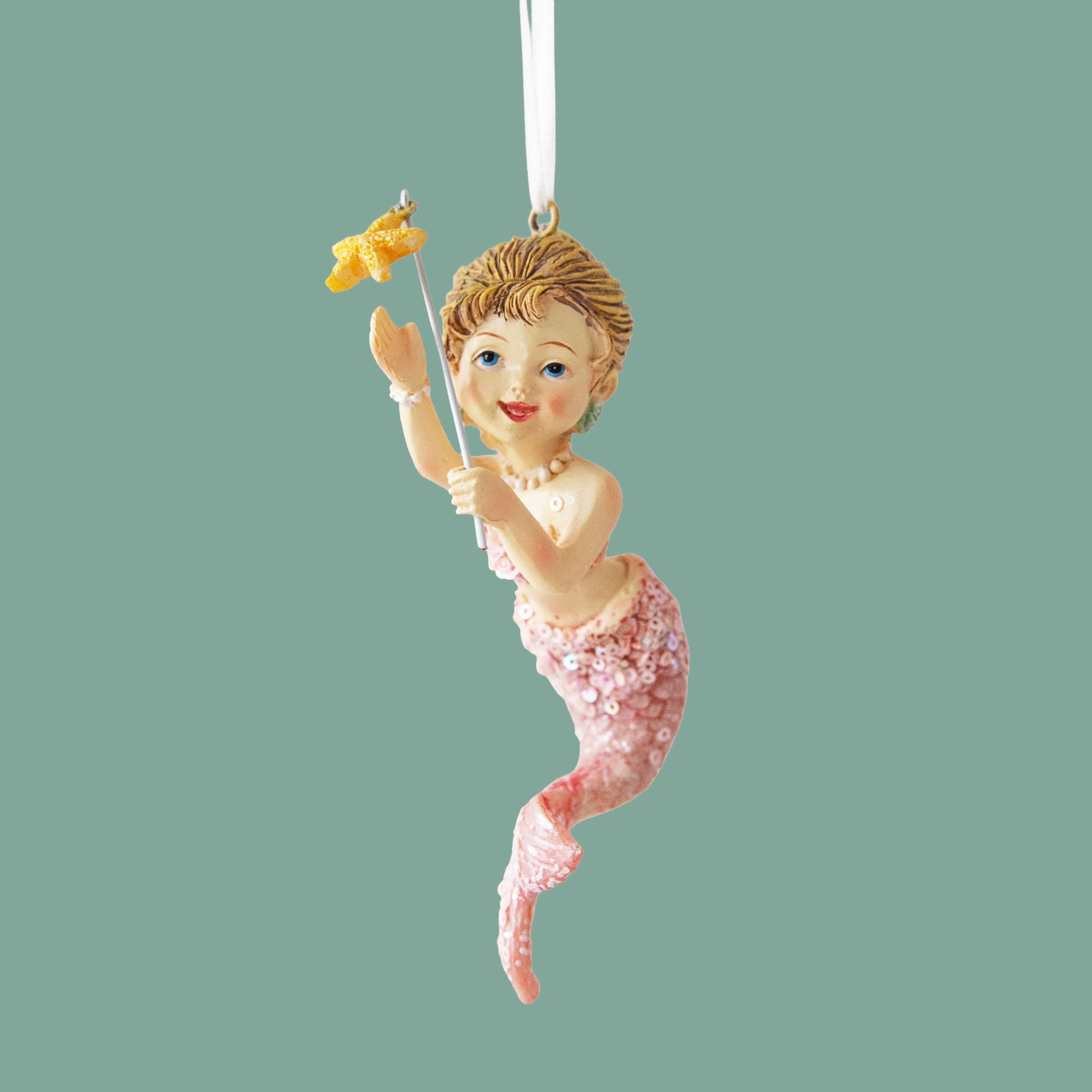 A mermaid shaped ornament with a starfish. 