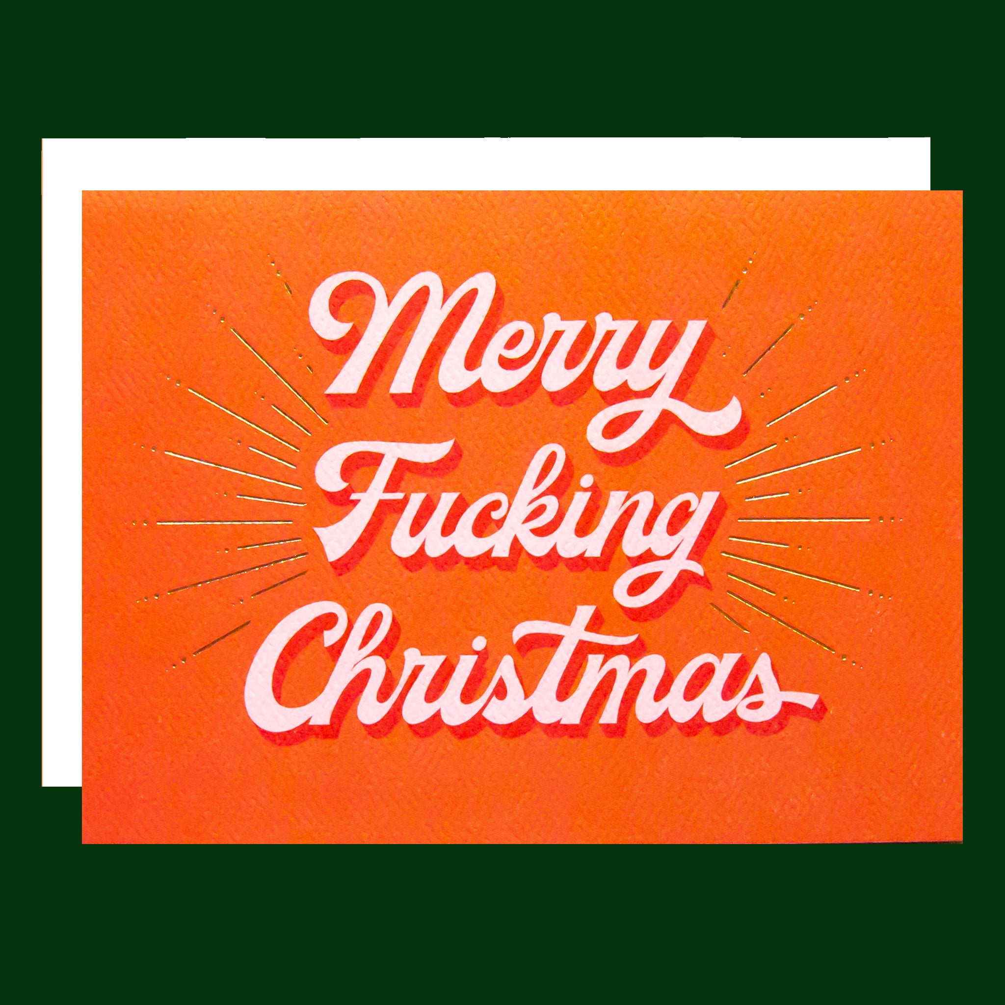Red card that reads 'Merry Fucking Christmas' in soft pink lettering with dark red shadowing. A gold foil burst detailing beams from the text