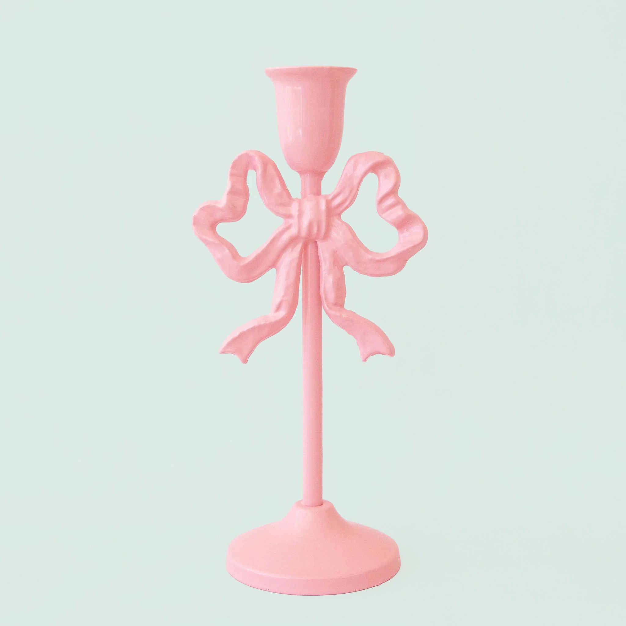 A pink bow shaped candle holder. 
