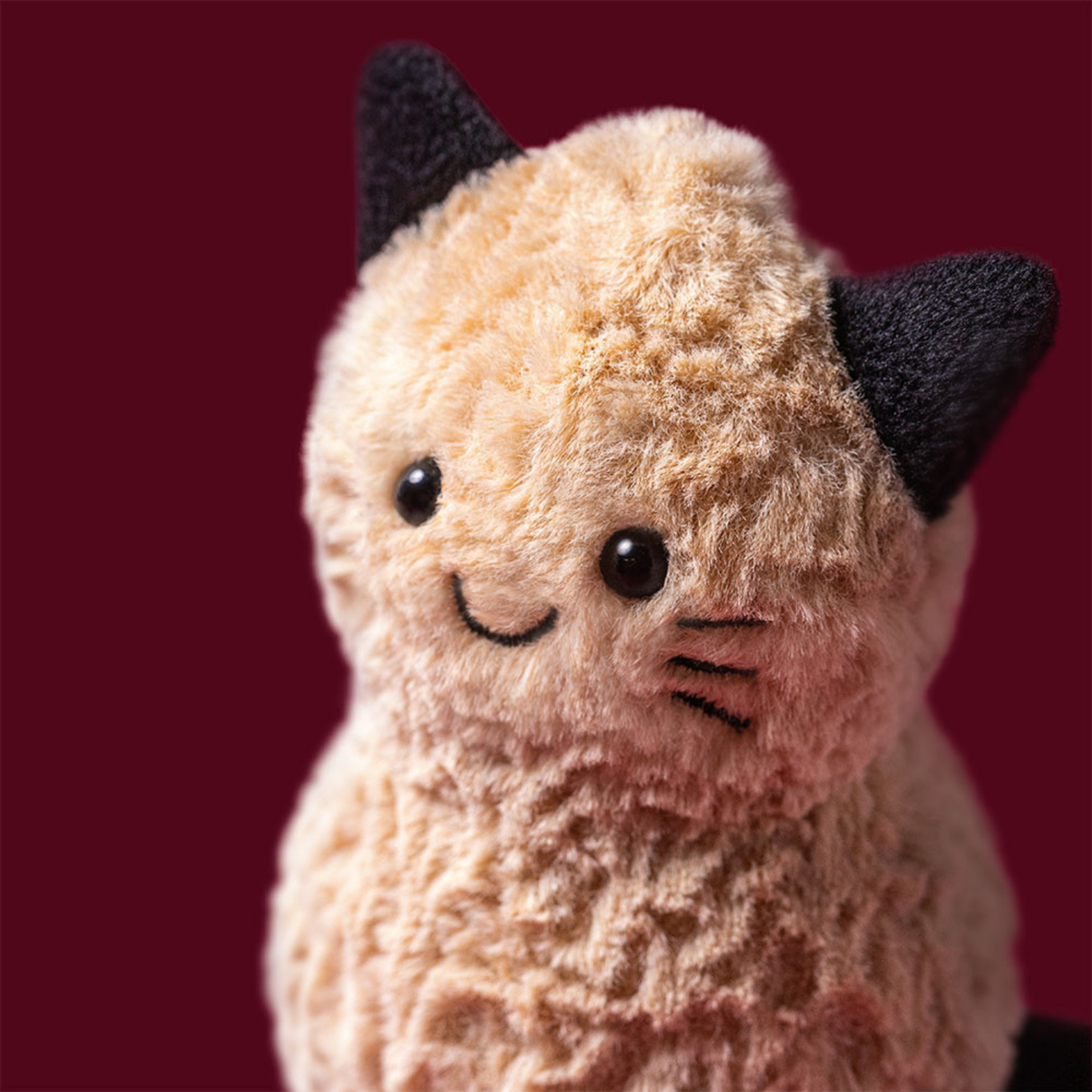 a peanut shaped plush toy wearing a cat costume.