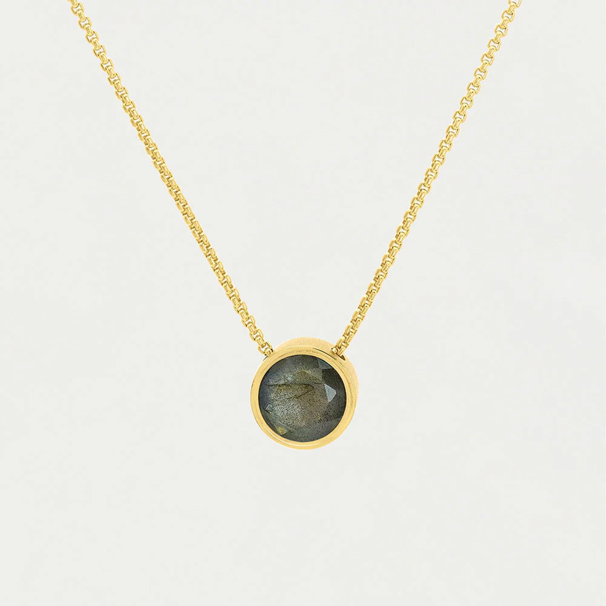 A gold chain necklace with a circle labradorite center. 
