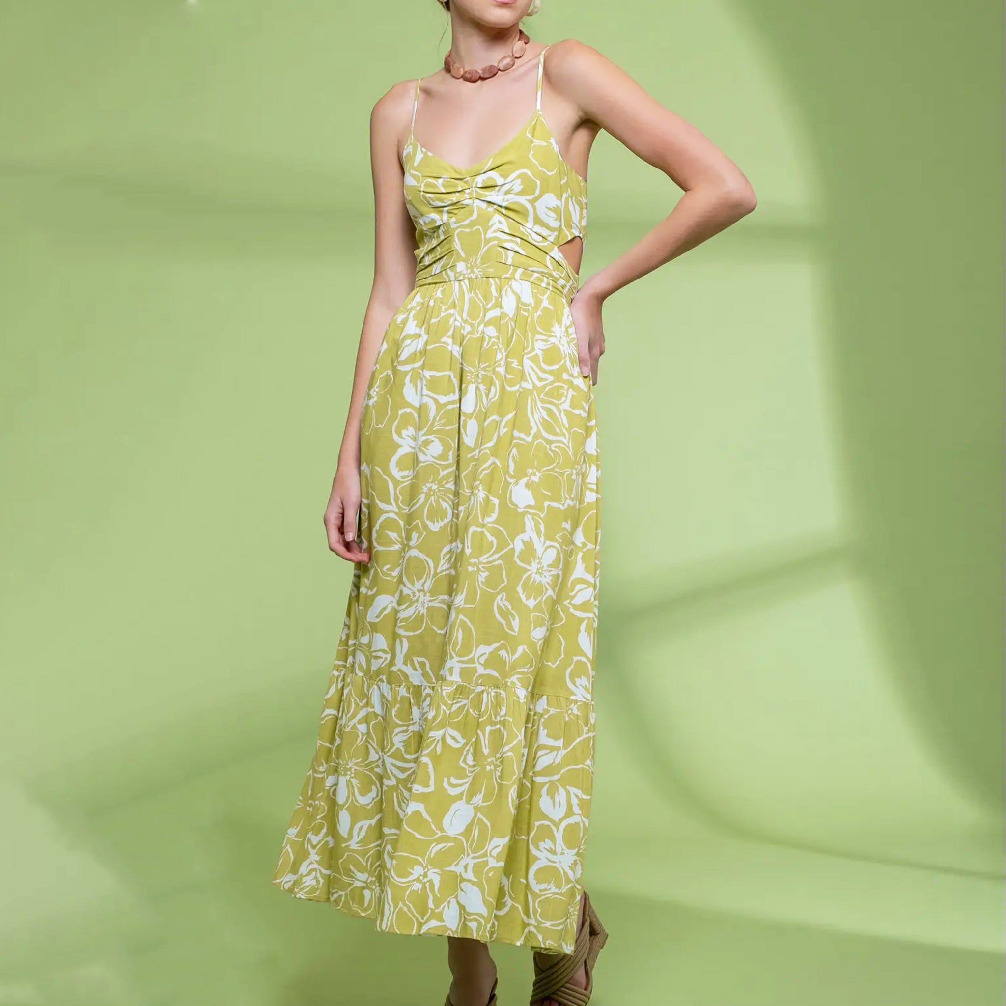 A lime green and white spaghetti strapped midi dress with a floral print. 