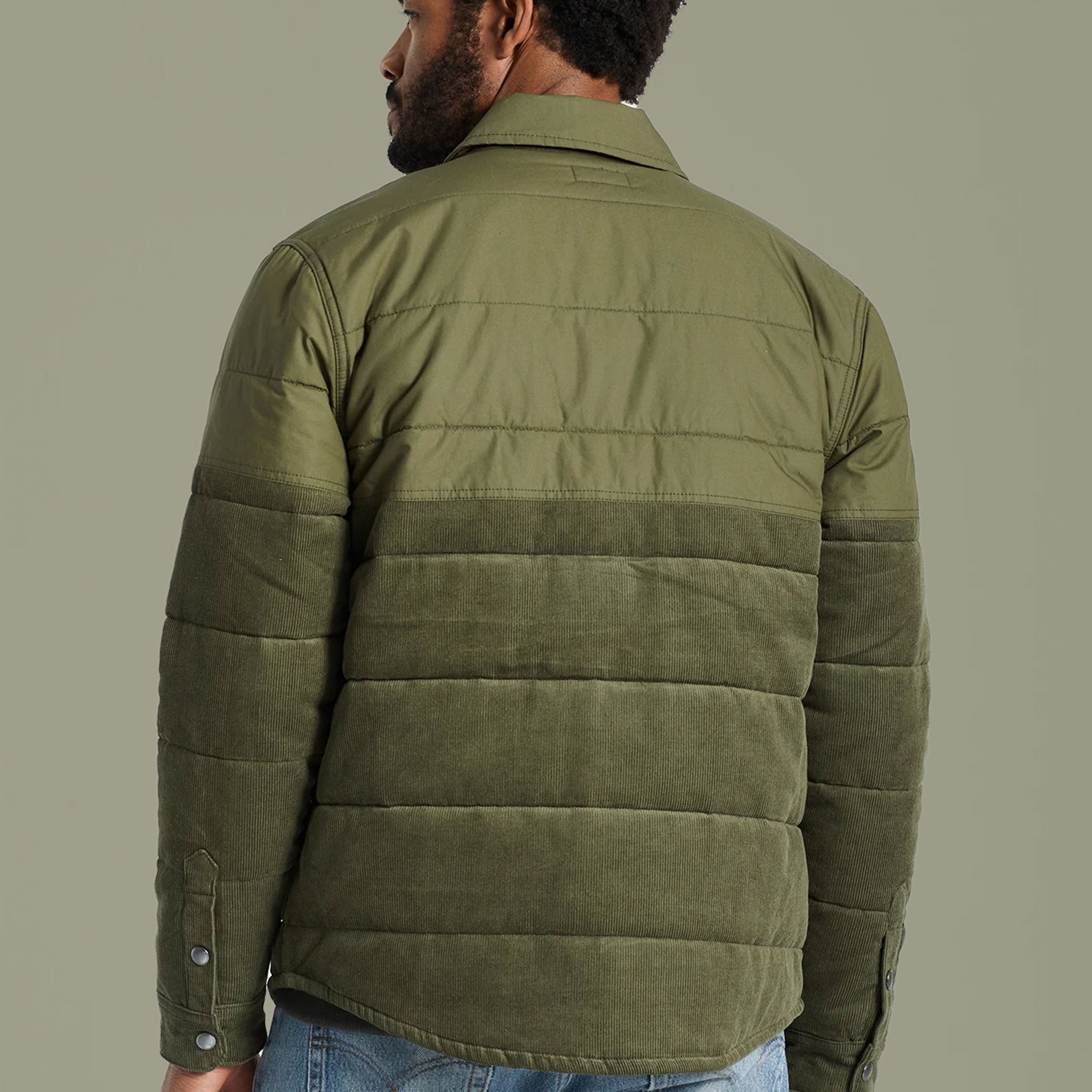On a white background is a model wearing an olive green jacket with half corduroy material.