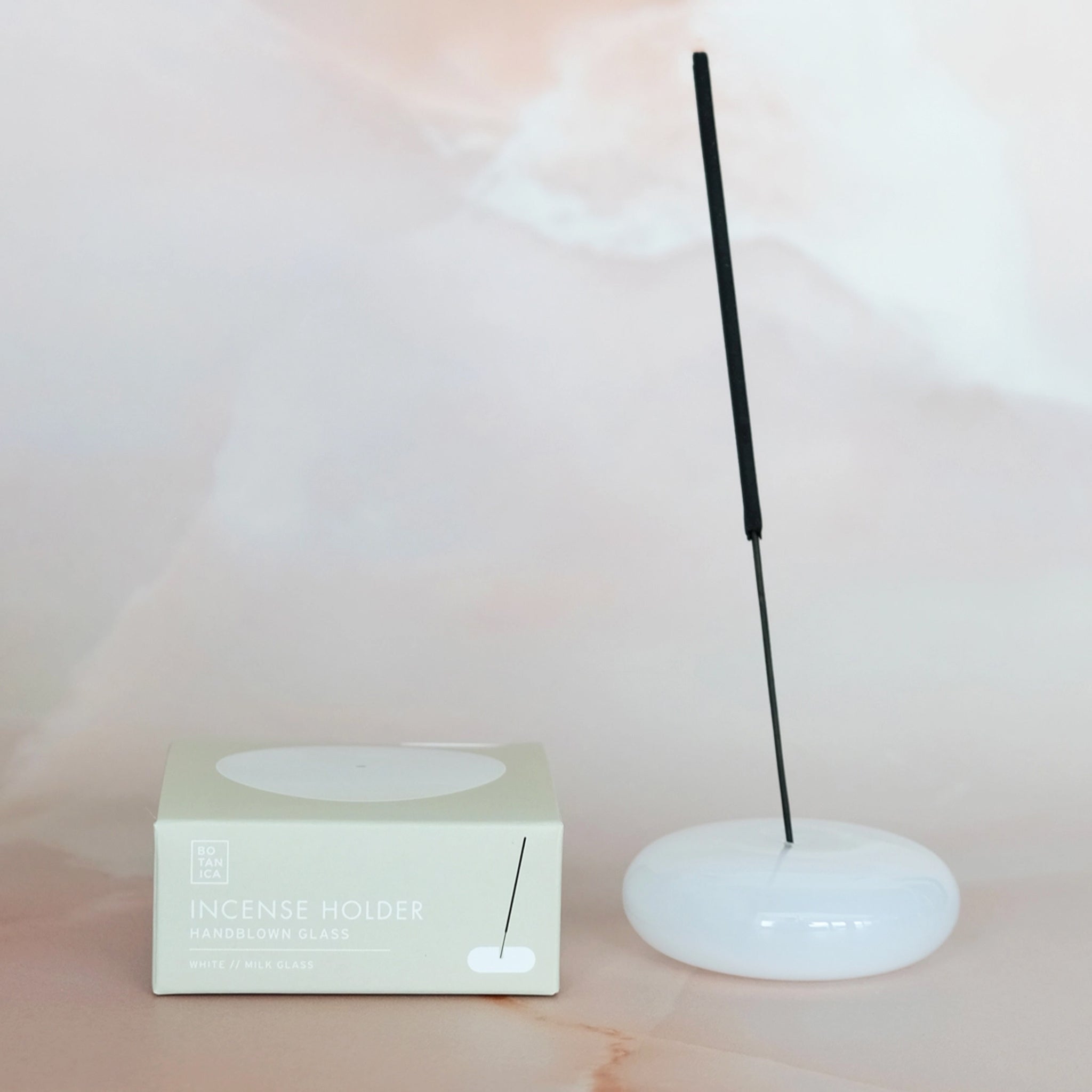 A milky white glass bubble incense holder. 
