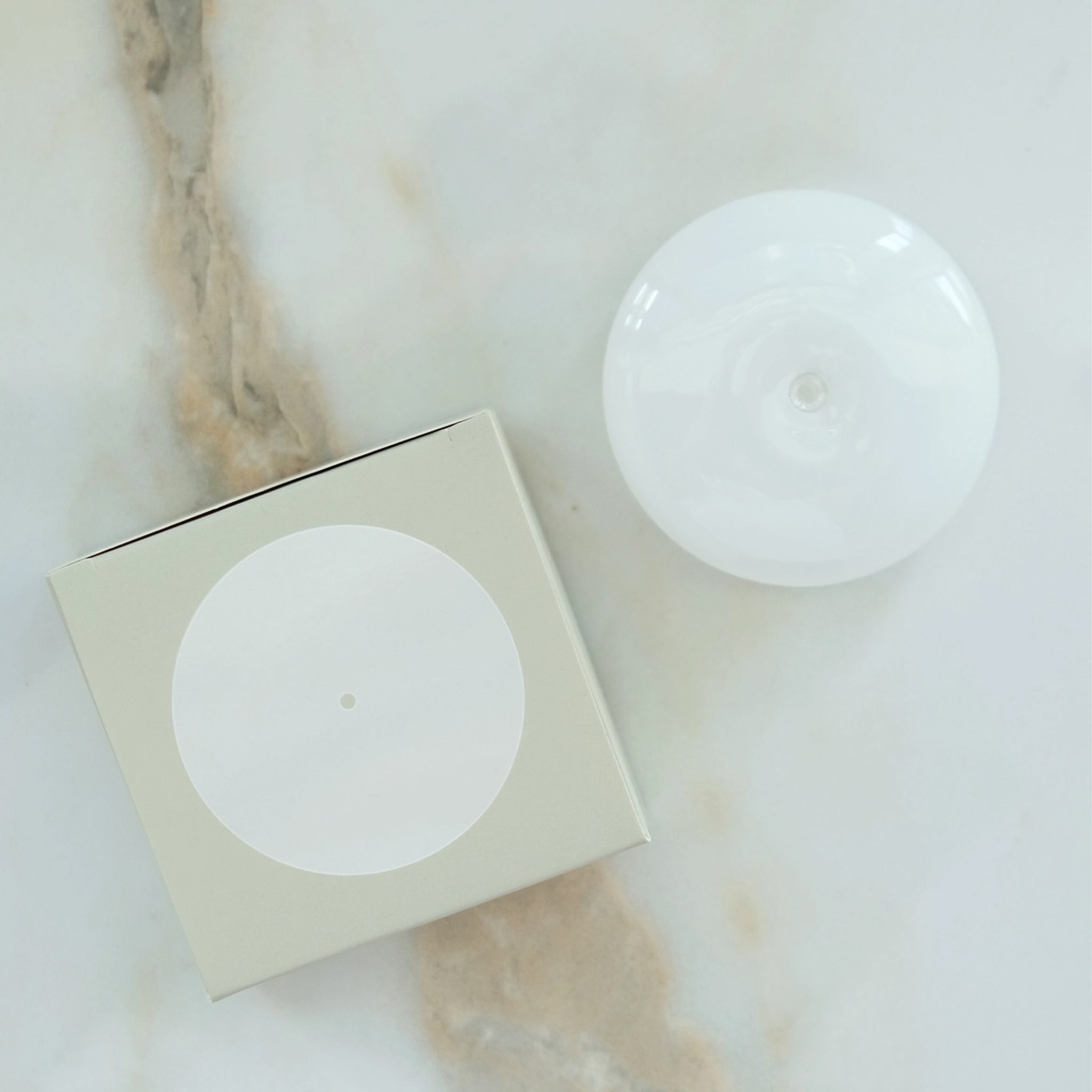 A milky white glass bubble incense holder. 