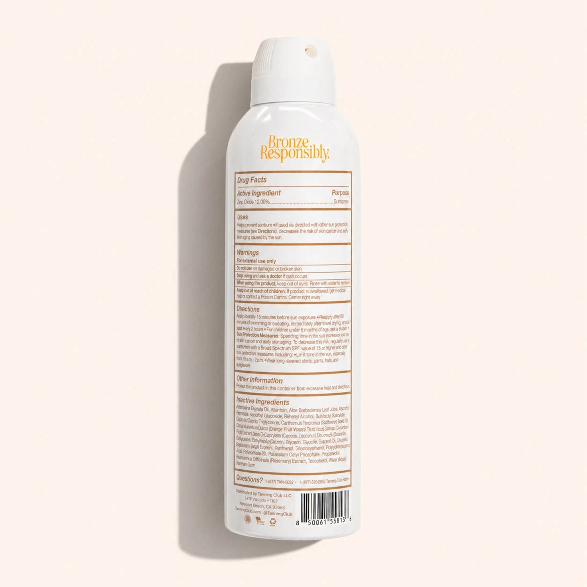 Tanning Club mineral sunscreen spray bottle on a beige background